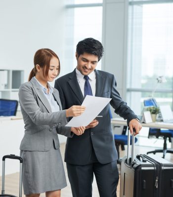 Male and female business professionals in suits reviewing documents in office